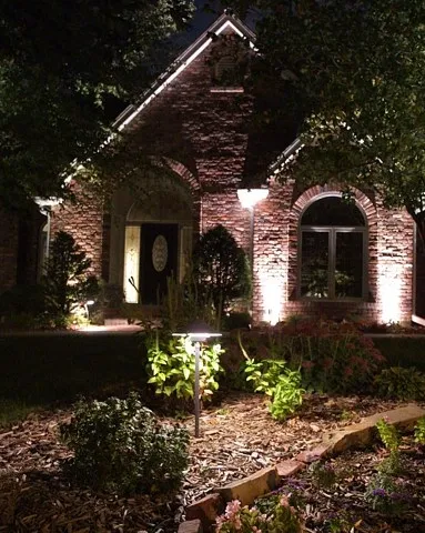 Brick home with warm uplighting and path lighting