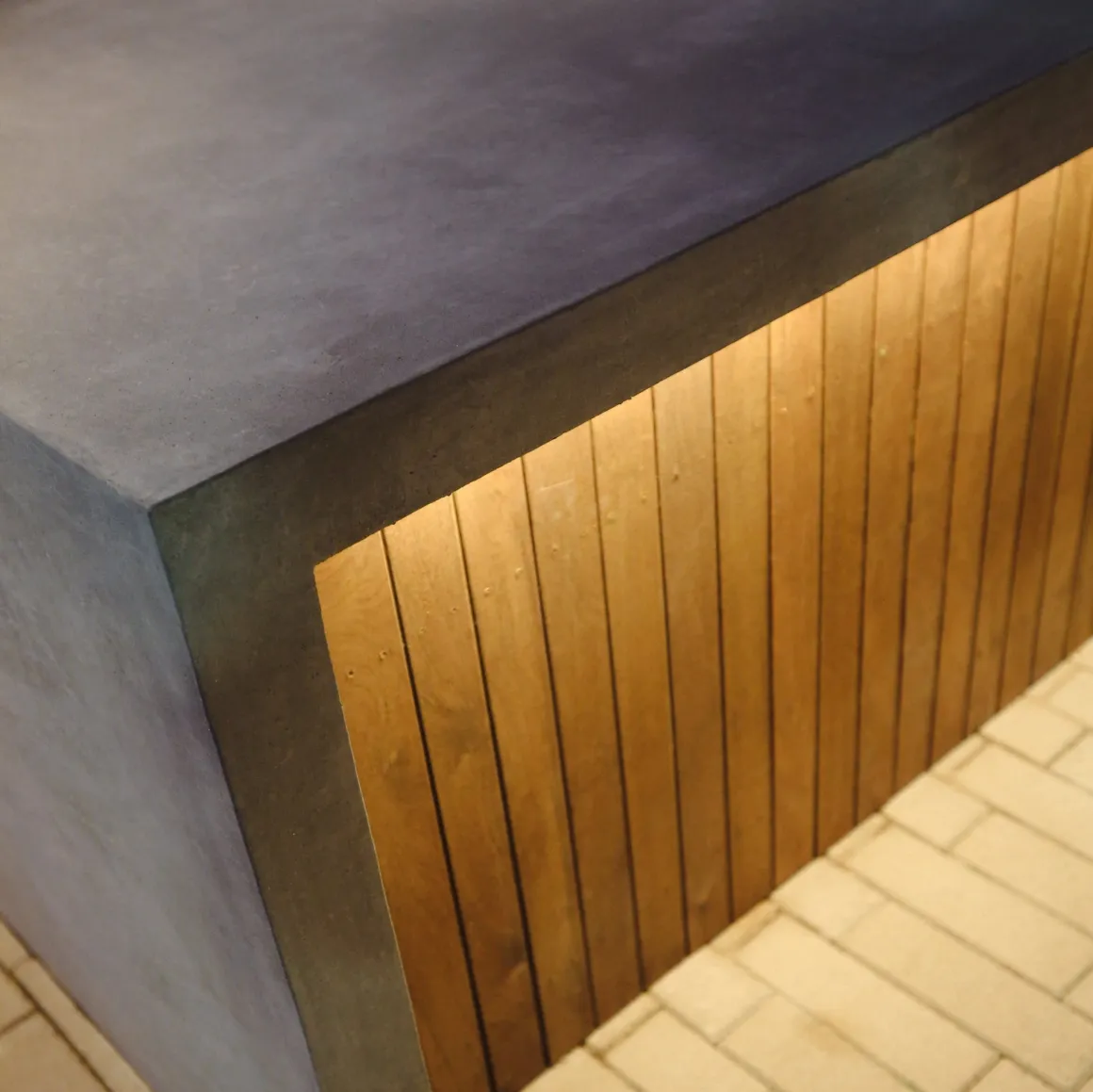 Warm under-edge lighting on a wood and concrete structure